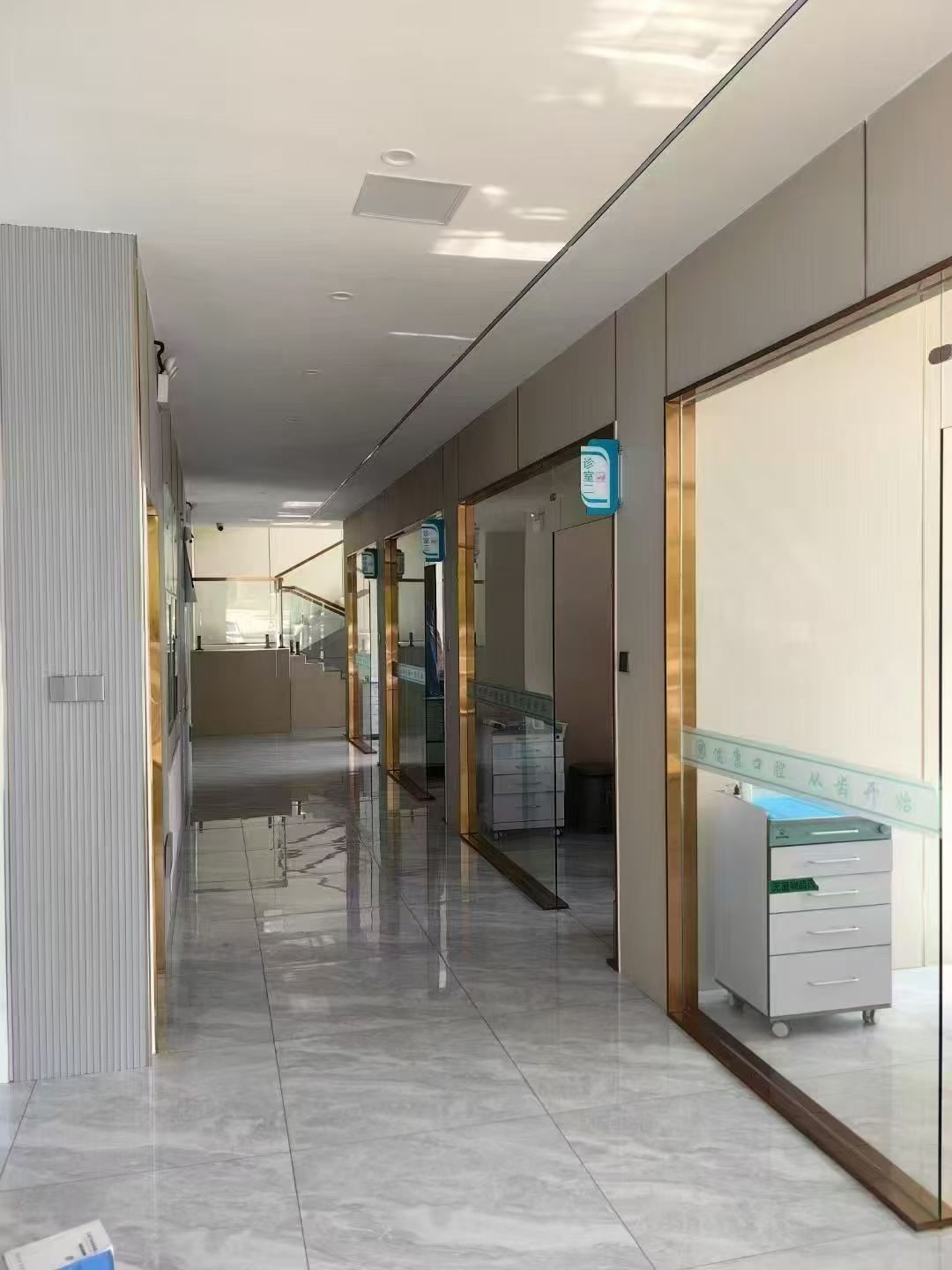 曹俊霞口腔诊区走廊实拍，两侧为金框玻璃门诊室